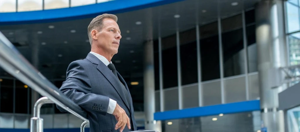 Executive in a business suit in a modern corporate atrium — executive transport programmes